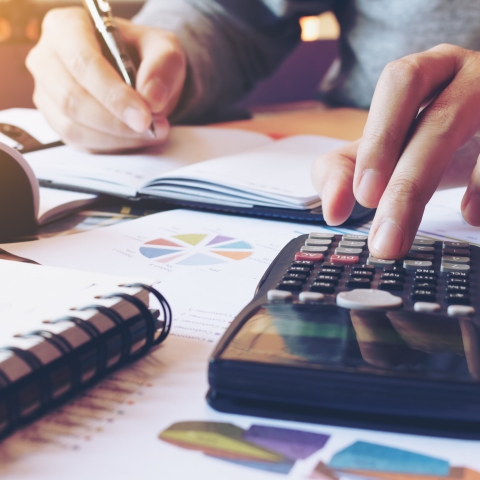 man using calculator at desk