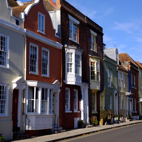 row of georgian style houses on a street with spinnaker tower in the background