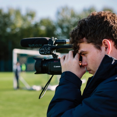 Ollie Marsh, journalist, filming a story