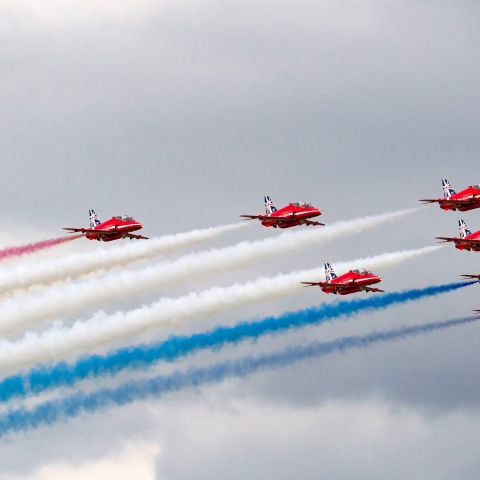 Red aeroplanes leaving smoke trails