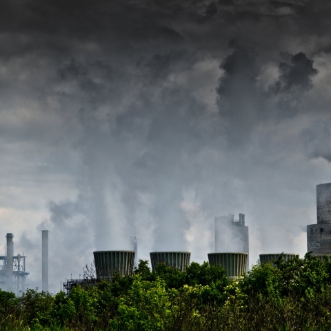 Pollution from factory rising into a dark grey sky