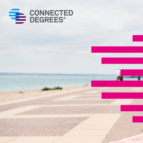 Two students sat at the beach, one wears a hat. There is a Connected Degrees logo top left. 