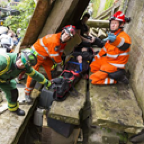 Emergency rescue crews treating a patient in collapsed building.