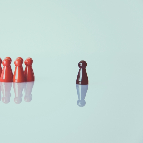 Group of red counters and one brown one