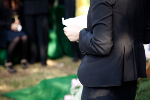 Person dressed in black holding a piece of paper 