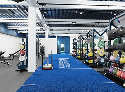 PEAC facility featuring dumbbells, kettle balls, turf and other gym equipment