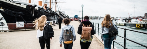 Students walk toward historical ship