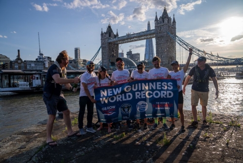 A team of six ocean rowers in front of Tower Bridge, London
