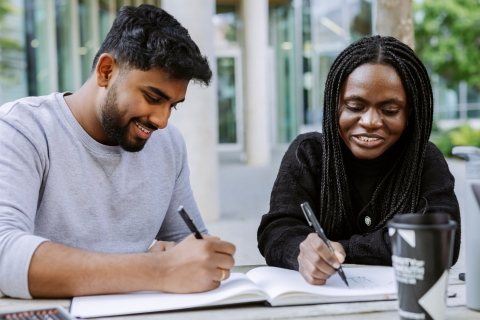 Two students working together from the same book in Eldon seating area