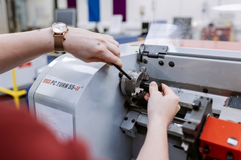 Female student making manual adjustments on large machine.
Technology Facilities Day One - NOT FOR THIRD PARTY - CONSENT