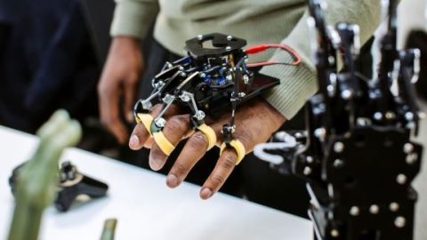 Man with robotic equipment covering hand